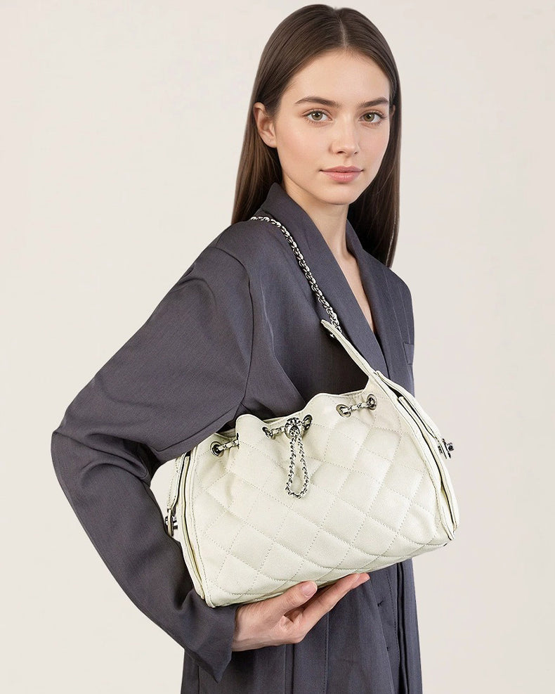Woman holding a white quilted handbag 
