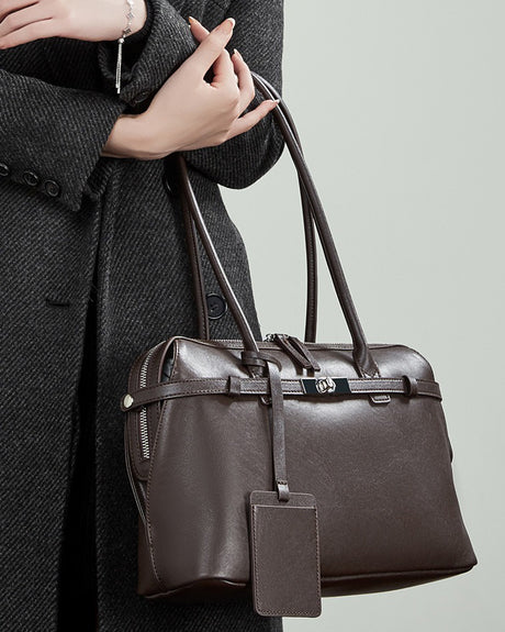 chocolate leather handbag with a tag held 